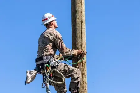 usace-lineman-climbing-a-power-pole.webp